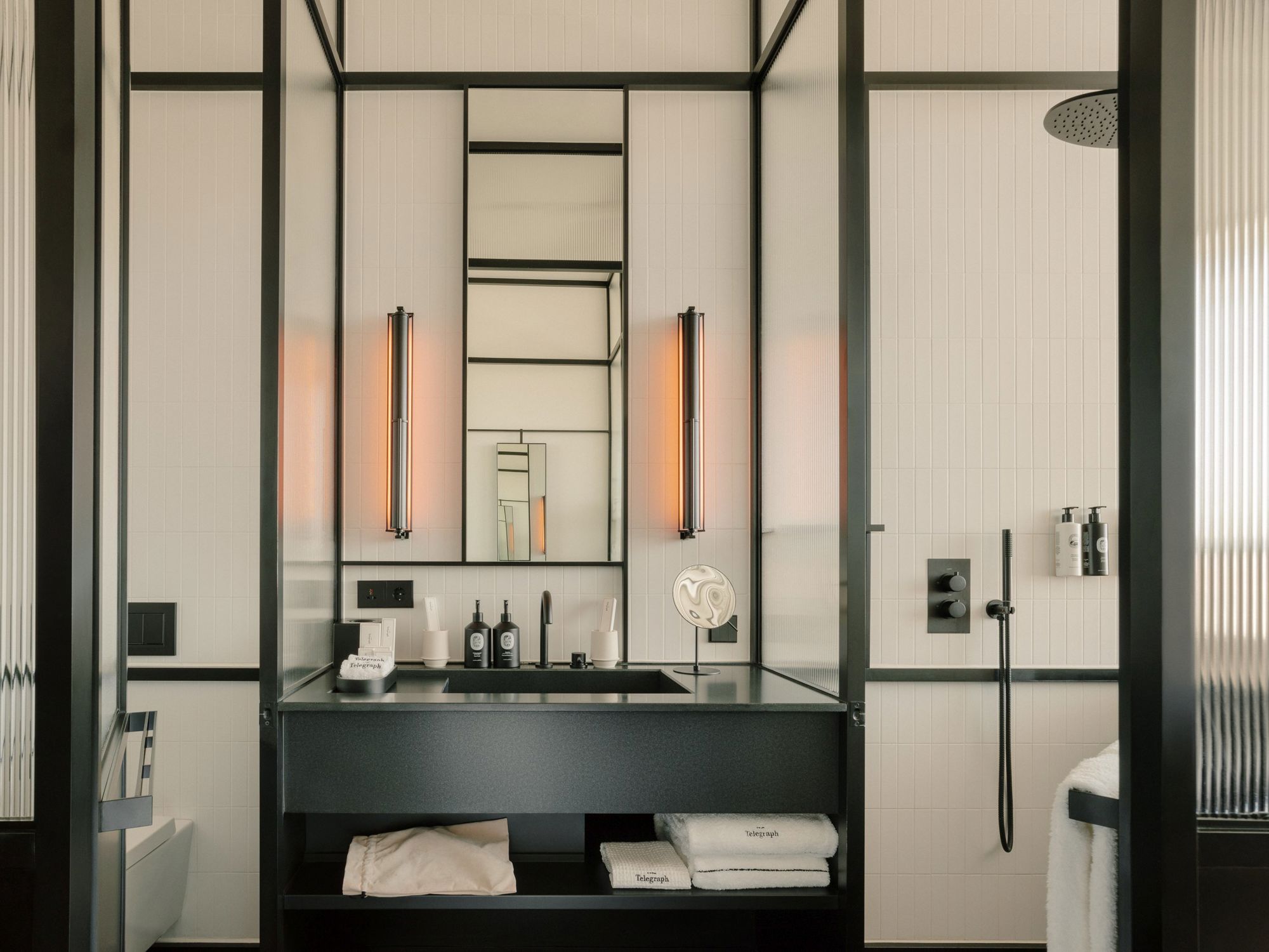 Spacious walk-in shower with grey slate tiles and a built-in bench.