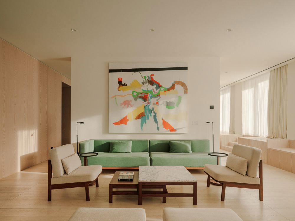 Interior of the Grand Terrace Club Suite designed by Neri & Hu, showcasing a blend of Brutalist architecture with warm wood accents, a king-sized bed, and an outdoor terrace with a view of Republic Square